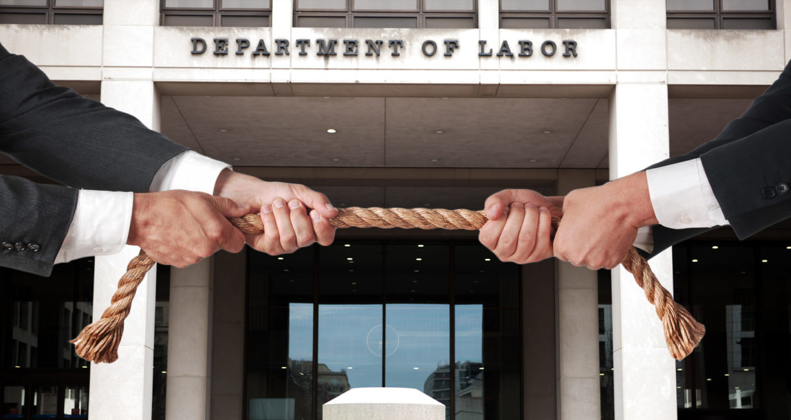 Image of two people pulling on a rope in a tug of war in front of the U.S. Department of Labor building.