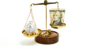 Image of a scale with cash on one side and a crumpled document on the other.