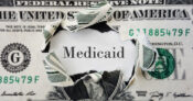 Image of the word "Medicaid" under a hole ripped in a dollar bill