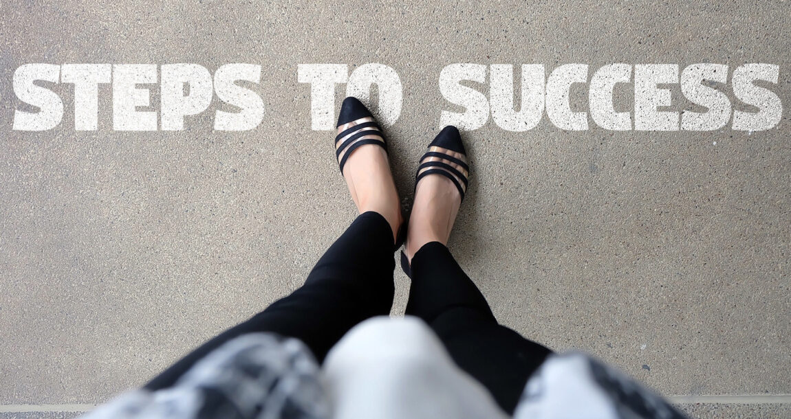 Image of a woman's feet standing on the words "Steps to Success."