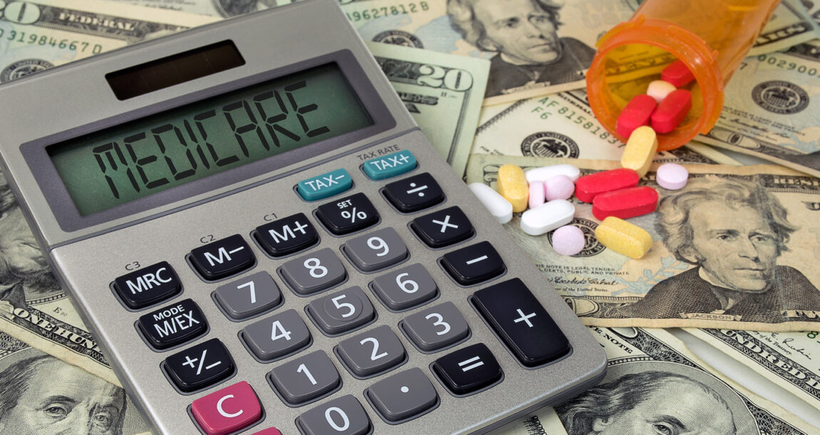 Image showing a calculator sitting atop high-denomination cash bills and prescription pills. Medicare Advantage carriers’ profit was double that of other markets, according to Kaiser Family Foundation.