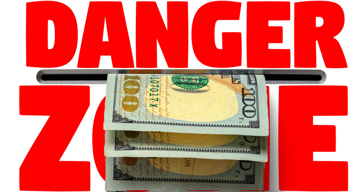Image of the words "Danger Zone" with cash coming out of slot between the words.