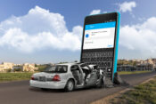 Image of a car smashed into a giant cell phone with texts on the screen. Distracted driving continues to spiral, with estimated costs in billions.