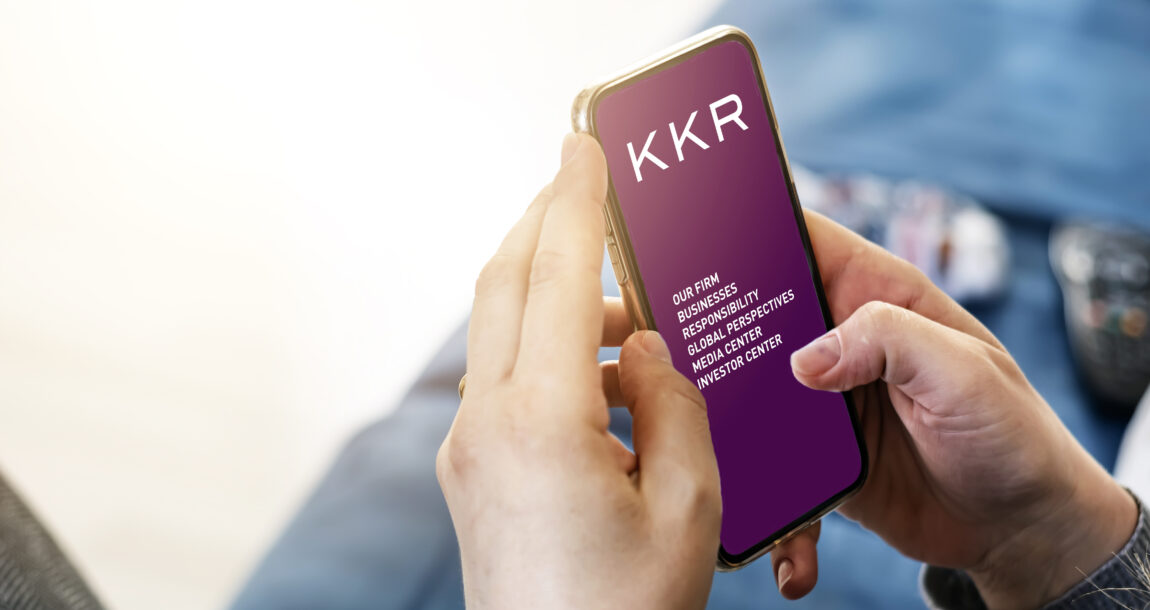 Image of person looking at KKR mobile site on cell phone. KKR & Co. beats estimates but sees earnings fall in Q1.