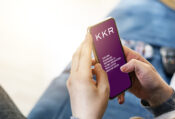 Image of person looking at KKR mobile site on cell phone. KKR & Co. beats estimates but sees earnings fall in Q1.