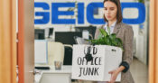 Image shows the Geico logo with a woman carrying office belongings in a box.
