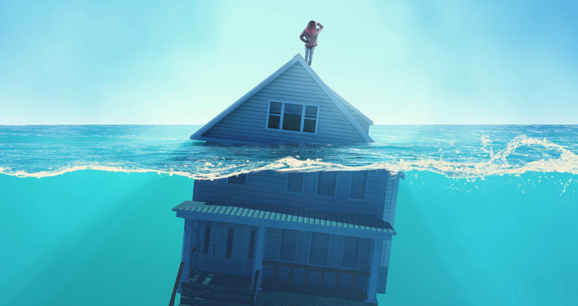 Illustration showing a person standing atop a house that is floating in water. Though risk increases, flood insurance purchases lag.