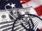 Image of hundred dollar bills and a stethoscope against a background of the American flag.