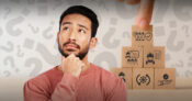 Image of man pondering against a background of building blocks with icons representing employee benefits.