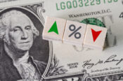 Image of a dollar bill with up and down arrows on either side of a percent sign.