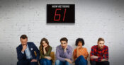 Image showing a waiting room full of young adults with an electronic sign in the background that says "Now retiring: 61."