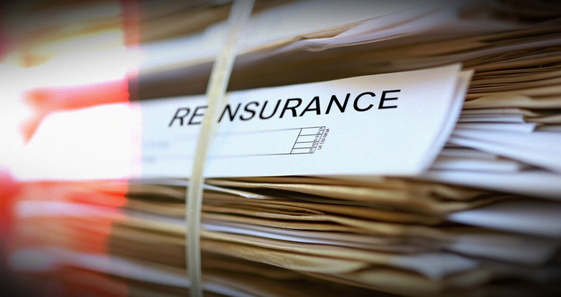 Image shows a stack of documents, with the word, "Reinsurance" on a paper.