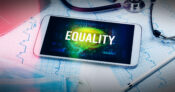 Image of smartphone sitting atop medical charts and equipment with the word "Equality" displayed. Regulators-urged-to-be-more-active-in-preventing-health-insurance-discrimination.