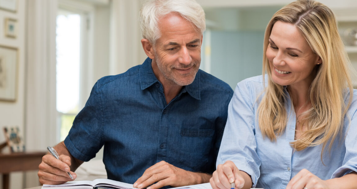 Image of a retirement-aged couple checking the details of their retirement planning. Retirement 'fluency' linked to retirement confidence, study finds.