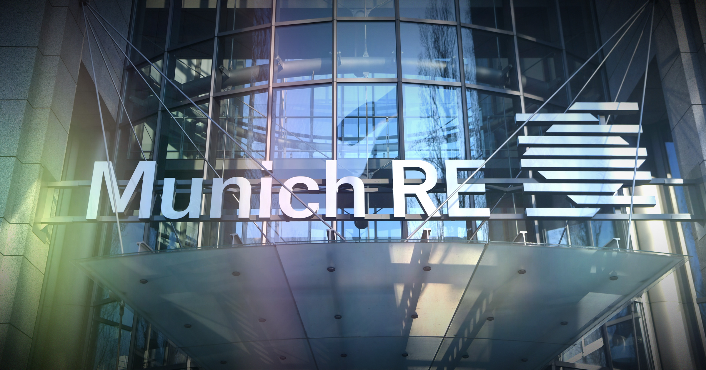 Image of Munich RE logo overlapping a modern office building. Munich-RE-says-EHRs-are-underutilized.
