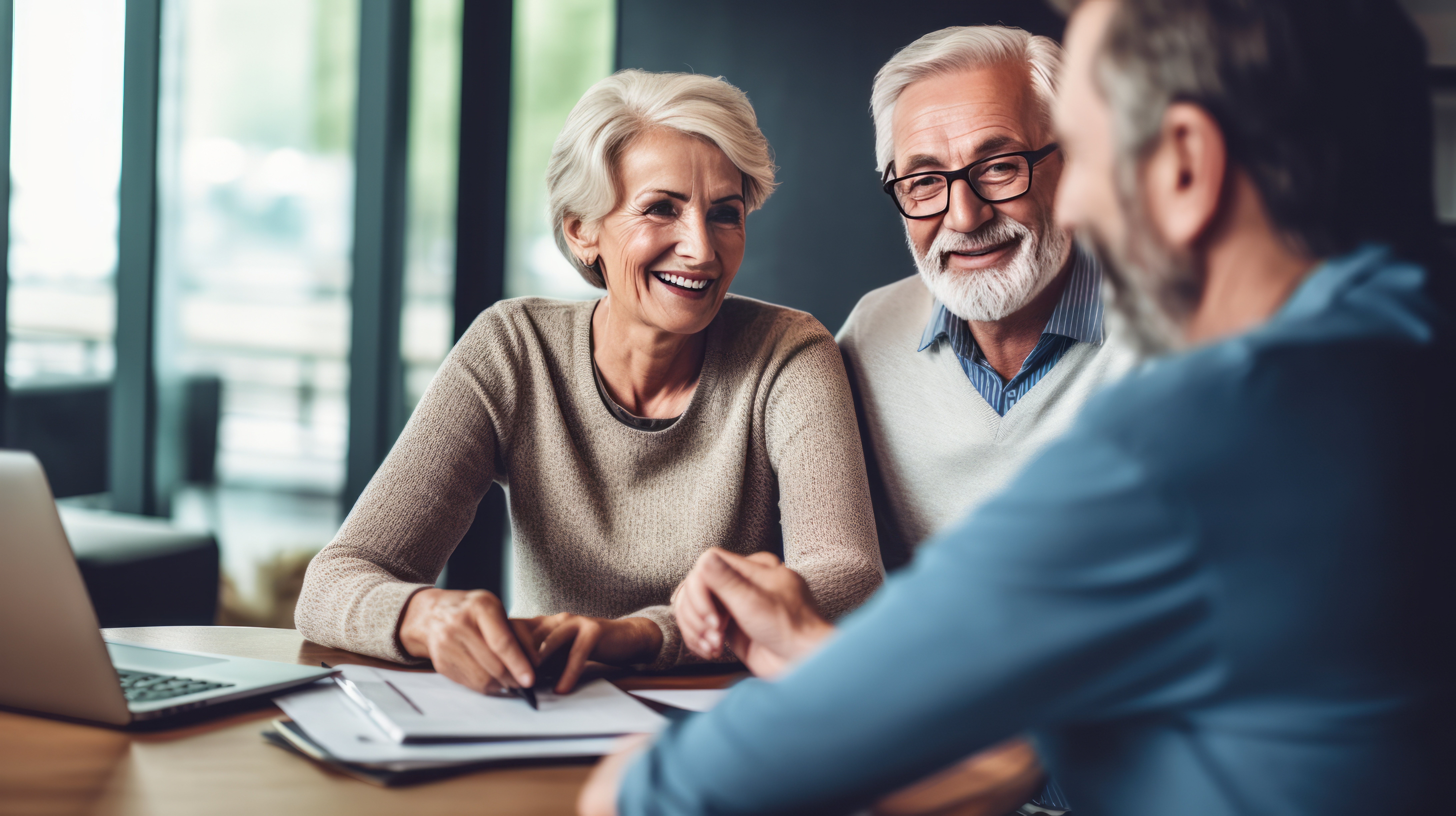 Image of a financial advisor and two senior age clients who look happy. Senior couple meeting financial advisor for investment.