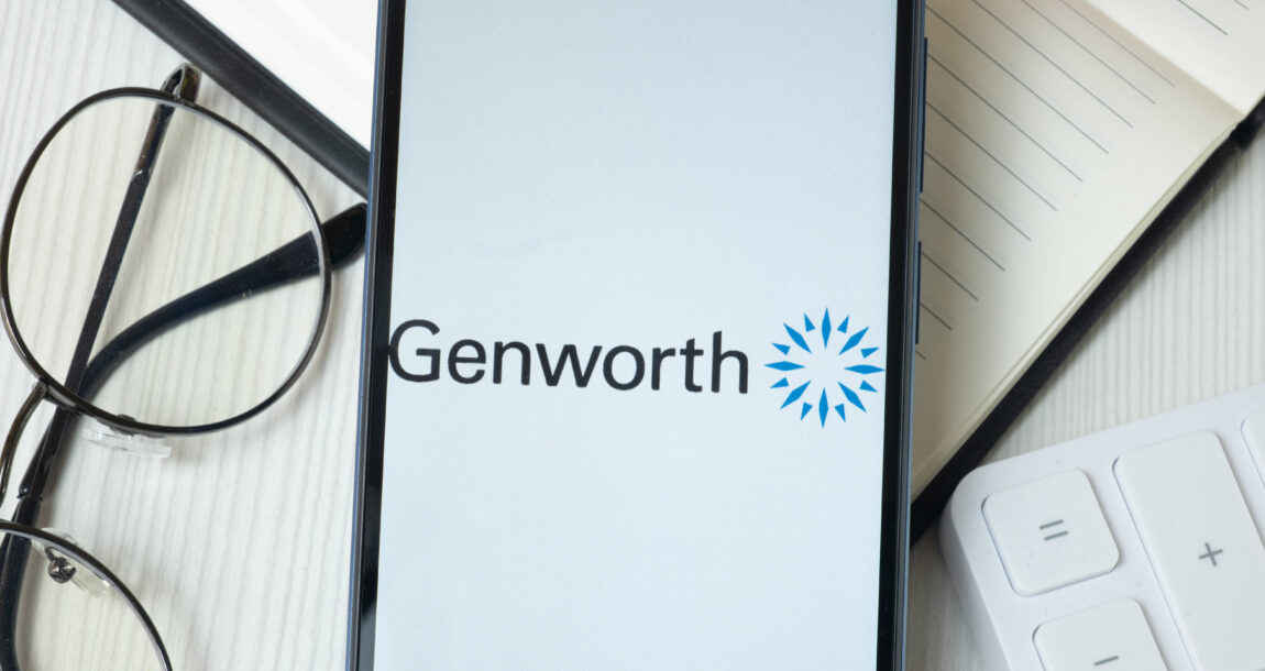 Smartphone with Genworth logo on screen sitting on a desk with financial reports and a pair of eyeglasses. Genworth reports strong third quarter earnings.