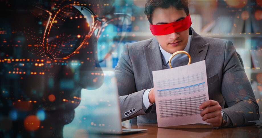 Man in business attire is holding a financial paper, but is blindfolded. Are-insurtechs-overlooking-the-basics-of-fraud-detection.