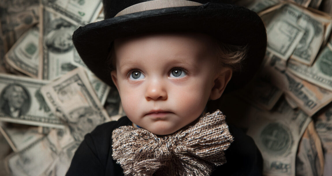 Image shows a baby surrounded by money.