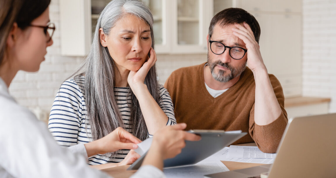 Advisor meeting with clients, neither looking very happy.