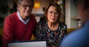 Image shows an older couple meeting with an advisor