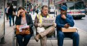 Image shows workers on a street bench