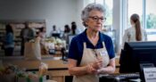 Image shows a woman running a cash register