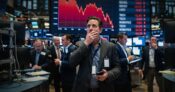 Image shows a stockbroker with his hand over his mouth.