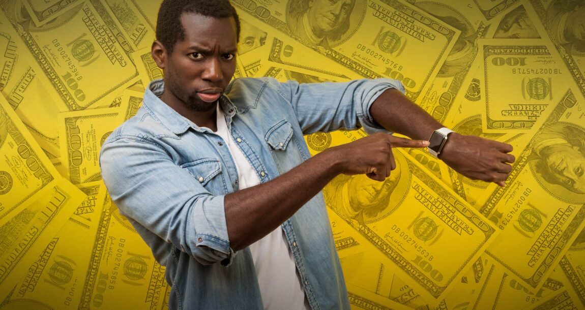 Image shows a man pointing at his watch